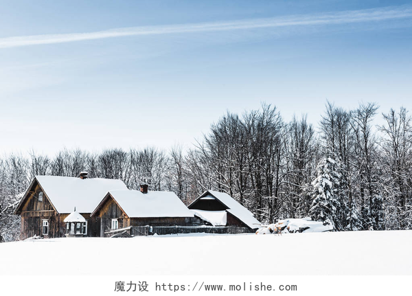 蓝天白云下的几个小木屋在喀尔巴泰山脉被雪覆盖的小木村 